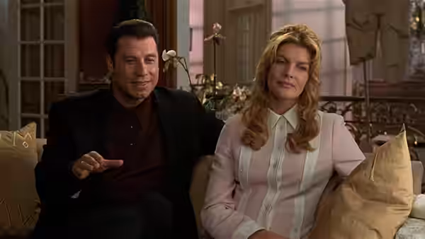 Chili Palmer (John Travolta) sits with Karen Flores (Rene Russo) on a couch