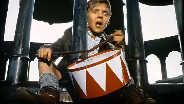 Oskar Matzerath (David Bennent) beats his red-and-white drum beneath a bell tower
