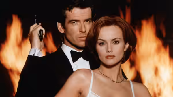 James Bond (Pierce Brosnan) and Xenia Onatopp standing before large flames