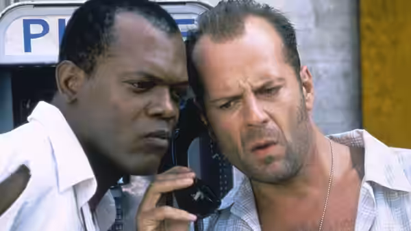 Zeus Carver holds a phone beside John McClane near a payphone