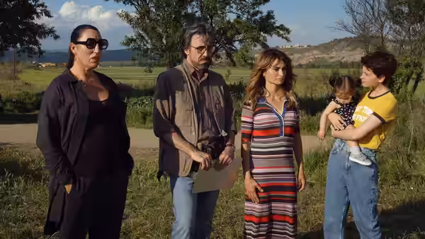 Teresa, Arturo, and Janis stand in a field as Ana holds her baby nearby