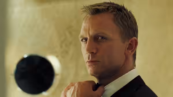 James Bond (Daniel Craig) adjusting his bow tie while glancing to the side
