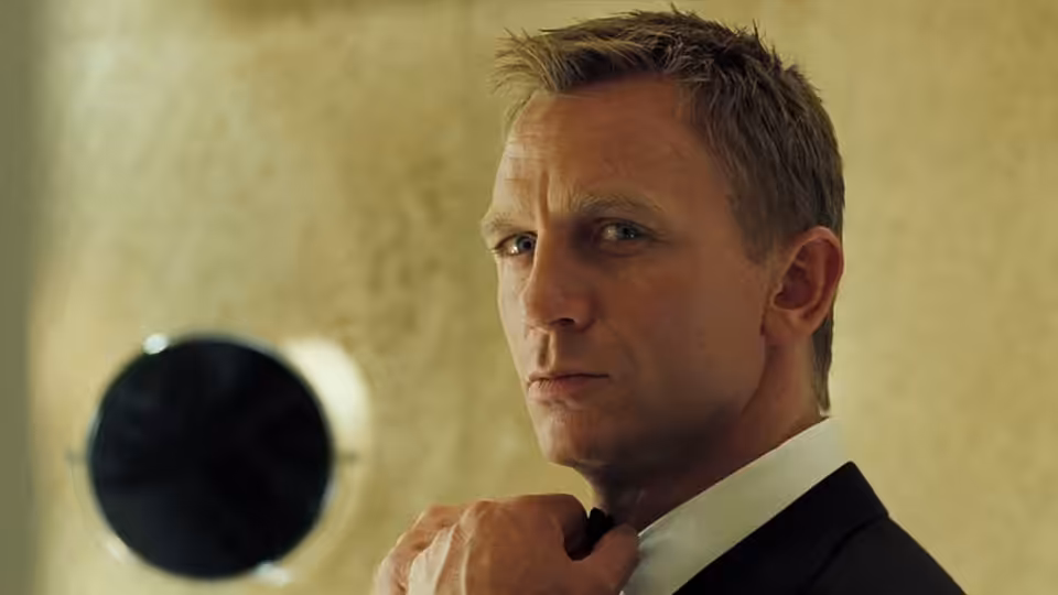 James Bond (Daniel Craig) adjusting his bow tie while glancing to the side