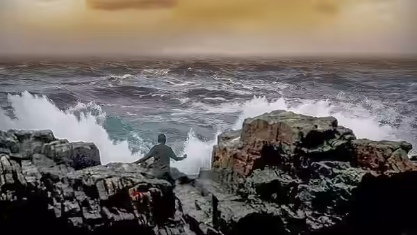 A woman standing on rocks facing a stormy sea with waves crashing around her