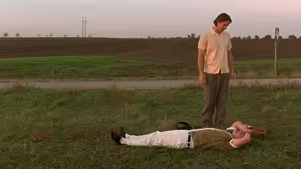 Anthony Adams (Luke Wilson) stands over Dignan (Owen Wilson) lying on grass by a road