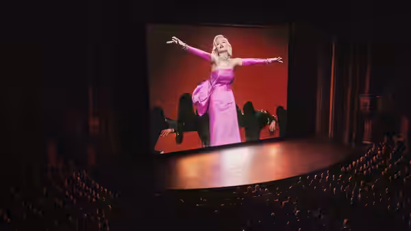 Marilyn Monroe (Ana de Armas) performs in a pink gown on a theater screen