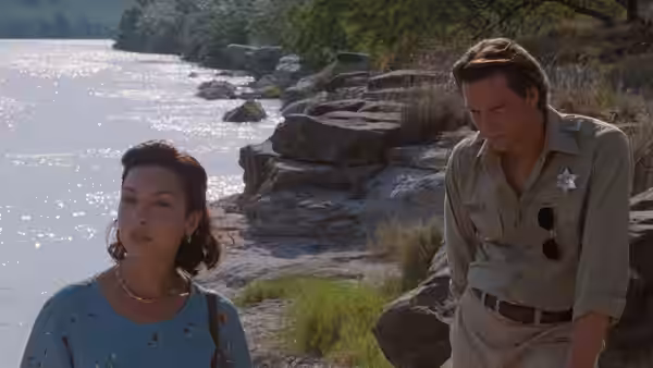 Pilar Cruz (Elizabeth Peña) standing by rocks with Sam Deeds (Chris Cooper)