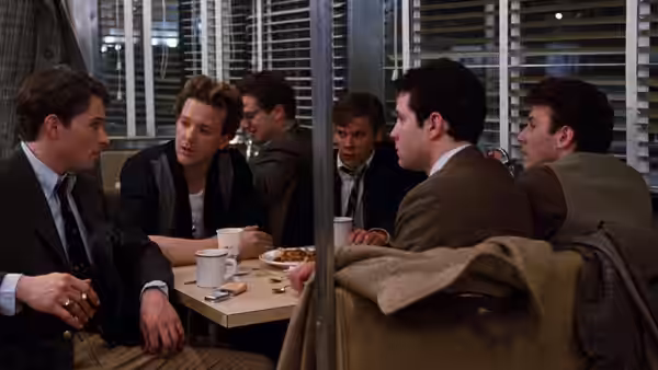 Group of men talking at a table inside a diner at night