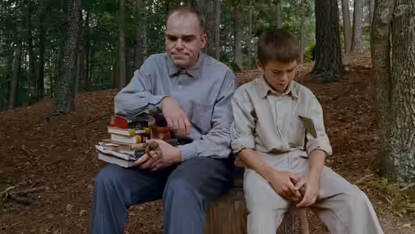 Karl Childers (Billy Bob Thornton) sits with Frank Wheatley in the woods