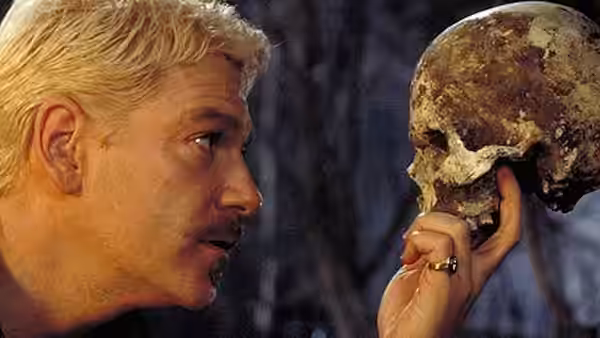 Prince Hamlet (Kenneth Branagh) holding a skull and looking at it