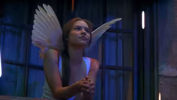 Juliet (Claire Danes) with angel wings clasping hands and looking upwards