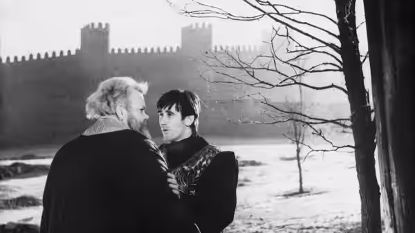 Falstaff (Orson Welles) and Prince Hal (Keith Baxter) face each other in a snowy castle courtyard
