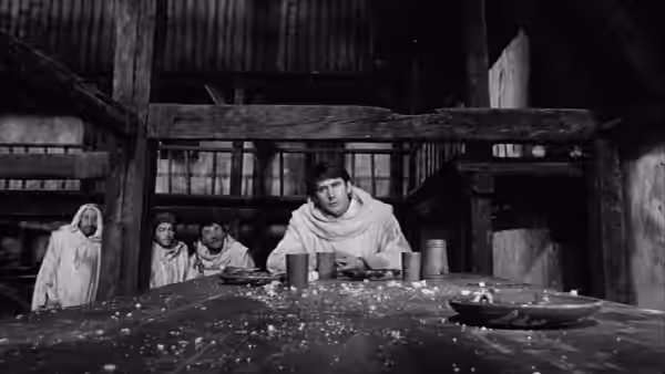 Prince Hal (Keith Baxter) sits at a table in a timbered tavern
