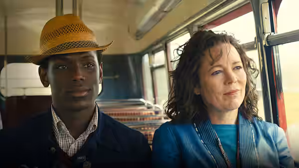 Stephen (Micheal Ward) and Hilary (Olivia Colman) sit together on a bus