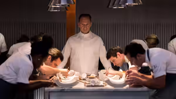 Chef Slowik (Ralph Fiennes) watches diners lean over their plates at the counter