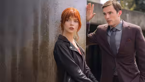 Tyler (Nicholas Hoult) raises a hand beside Margot (Anya Taylor-Joy) outside