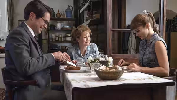 Ada Harris (Lesley Manville) shares a meal with a man and young woman