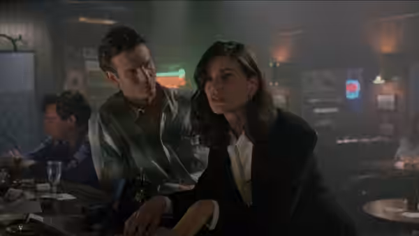 Bridget Gregory (Linda Fiorentino) sits at a bar as a man leans close beside her