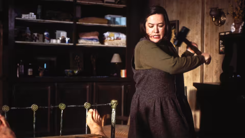 Annie Wilkes (Kathy Bates) swinging a sledgehammer in a bedroom