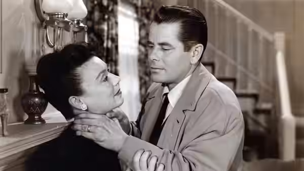 Dave Bannion grips a woman by the neck beside a staircase