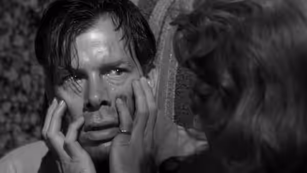 Debby Marsh holds a man's face as he looks ahead tearfully