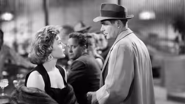 Debby Marsh looks up at Dave Bannion as they talk in a crowded club
