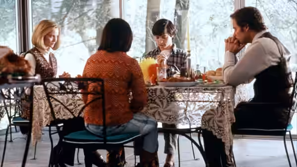 Ben Hood (Kevin Kline) and family seated at a dining table with Janey Carver (Sigourney Weaver)