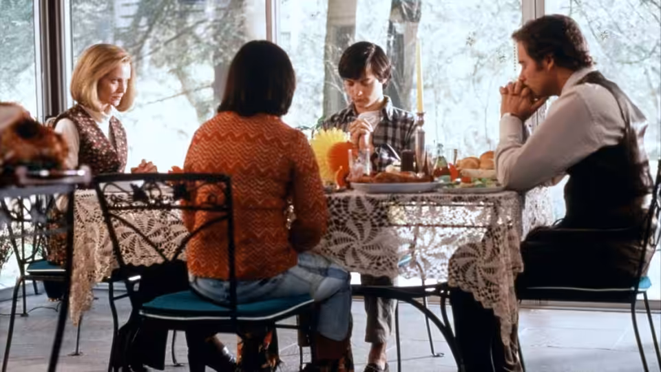 Ben Hood (Kevin Kline) and family seated at a dining table with Janey Carver (Sigourney Weaver)