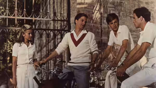 Four young people stand among bicycles in the garden