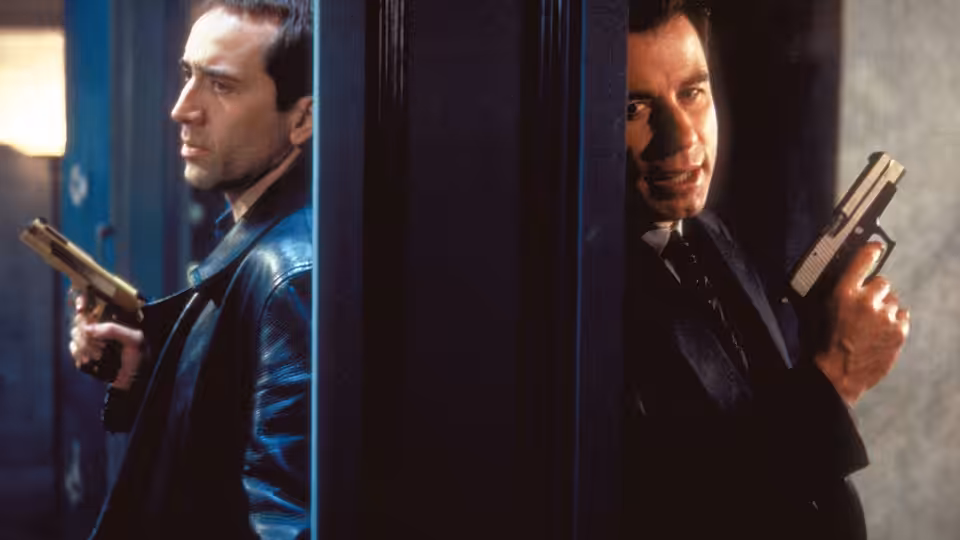 Castor Troy (Nicolas Cage) and Sean Archer (John Travolta) aiming pistols from behind a pillar