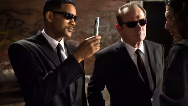 Jay (Will Smith) showing a silver device to Kay and another man