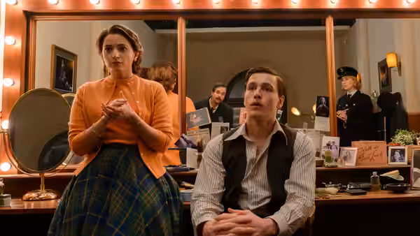 A woman and a seated man wait in a dressing room as Constable Stalker watches