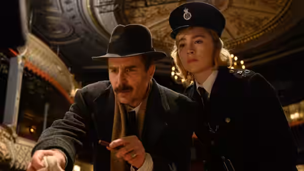 Inspector Stoppard (Sam Rockwell) and Constable Stalker (Saoirse Ronan) lean over a table indoors
