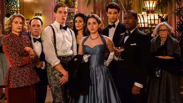 Constable Stalker (Saoirse Ronan) stands among formally dressed guests at a crowded reception
