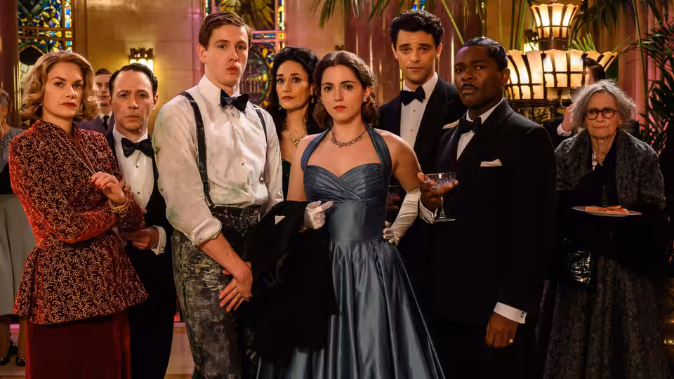 Constable Stalker (Saoirse Ronan) stands among formally dressed guests at a crowded reception