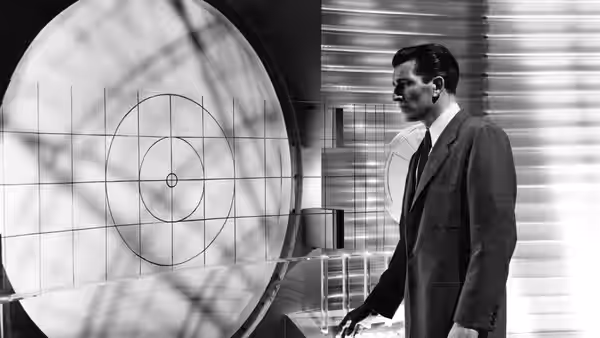 Klaatu (Michael Rennie) stands beside a large radar display in a control room