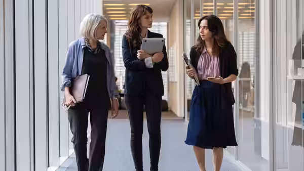 Megan Twohey (Carey Mulligan), Rebecca Corbett (Patricia Clarkson) and a colleague walk through a newsroom corridor