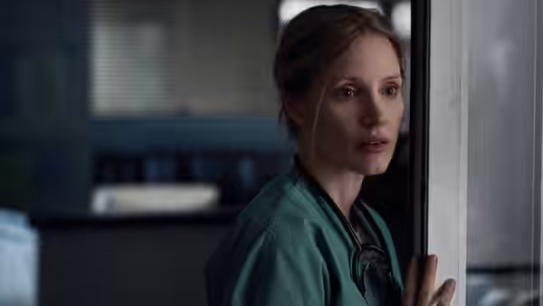 Amy Loughren (Jessica Chastain) peers around a doorway in her hospital scrubs