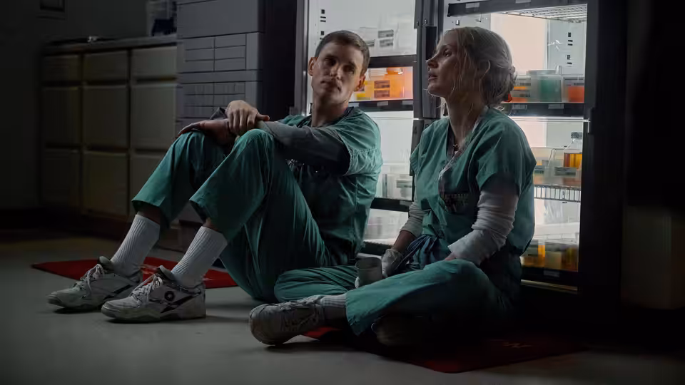 Amy Loughren (Jessica Chastain) and Charles Cullen (Eddie Redmayne) sit on the hospital floor