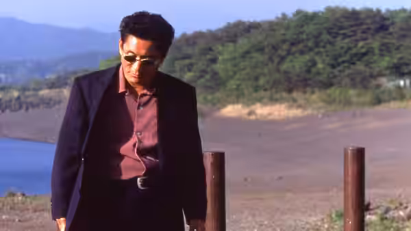 Yoshitaka Nishi (Takeshi Kitano) walking along a riverbank