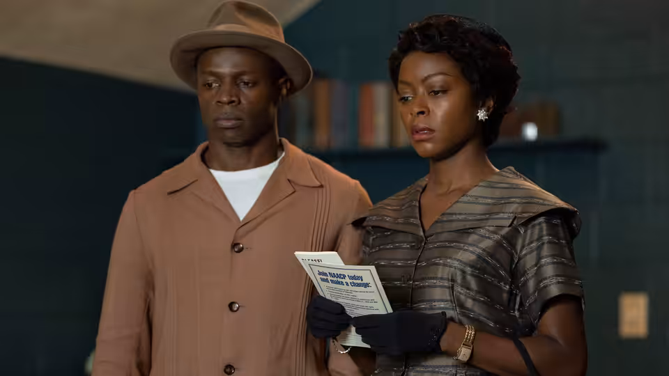 Mamie Till-Mobley (Danielle Deadwyler) and Gene Mobley (Sean Patrick Thomas) read a pamphlet indoors