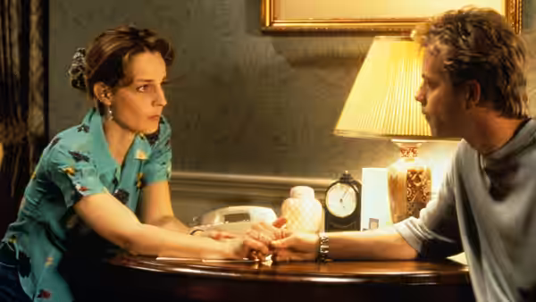 Carol Connelly (Helen Hunt) and Simon Bishop (Greg Kinnear) holding hands at a table