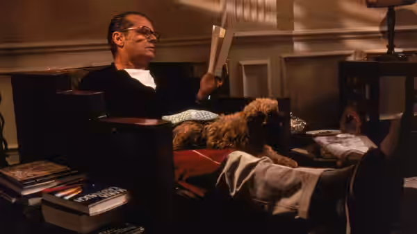 Melvin Udall (Jack Nicholson) reading papers in an armchair with his dog