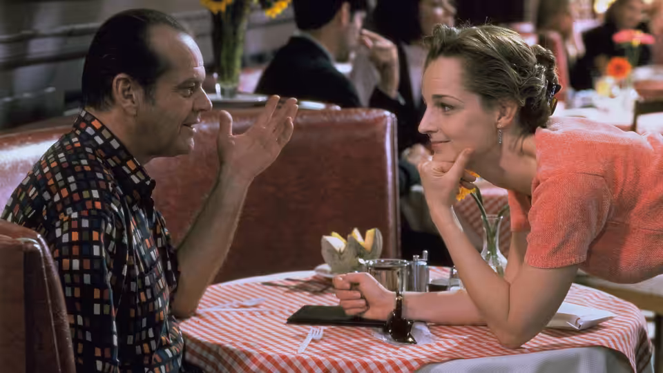 Melvin Udall (Jack Nicholson) and Carol Connelly (Helen Hunt) talking at a restaurant table