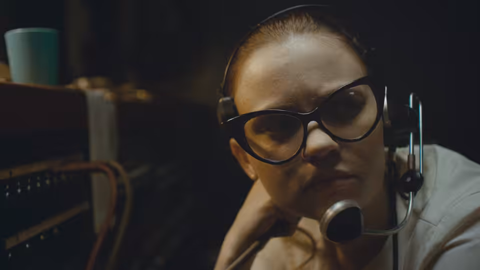 Fay Crocker (Sierra McCormick) wears a headset at the radio console