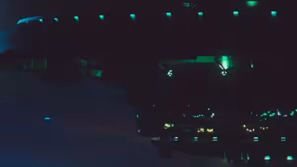 A dark radio studio glows with green indicator lights across its broadcasting equipment