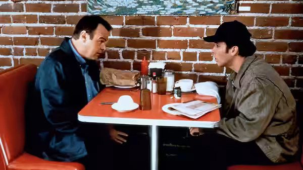 Martin Blank (John Cusack) seated across from another man in a diner booth