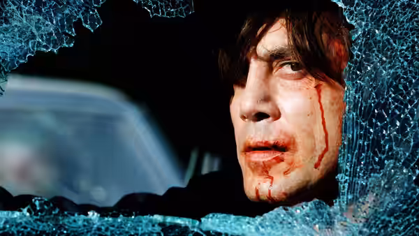 Llewelyn Moss (Josh Brolin) looks through shattered glass with blood on his face