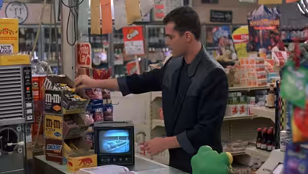 Charles Driggs reaches across the counter for M&M's in a convenience store
