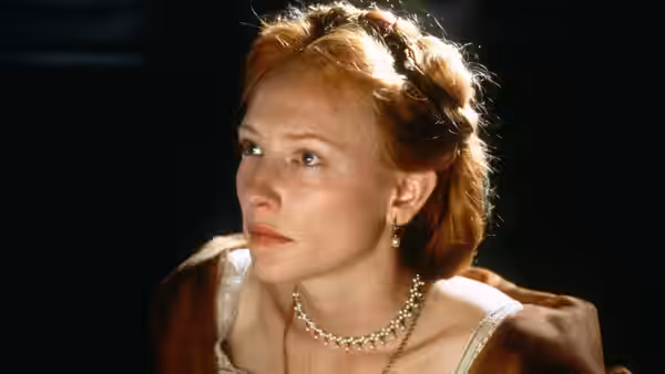 Elizabeth (Cate Blanchett) gazing to the side with braided hair and pearl necklace